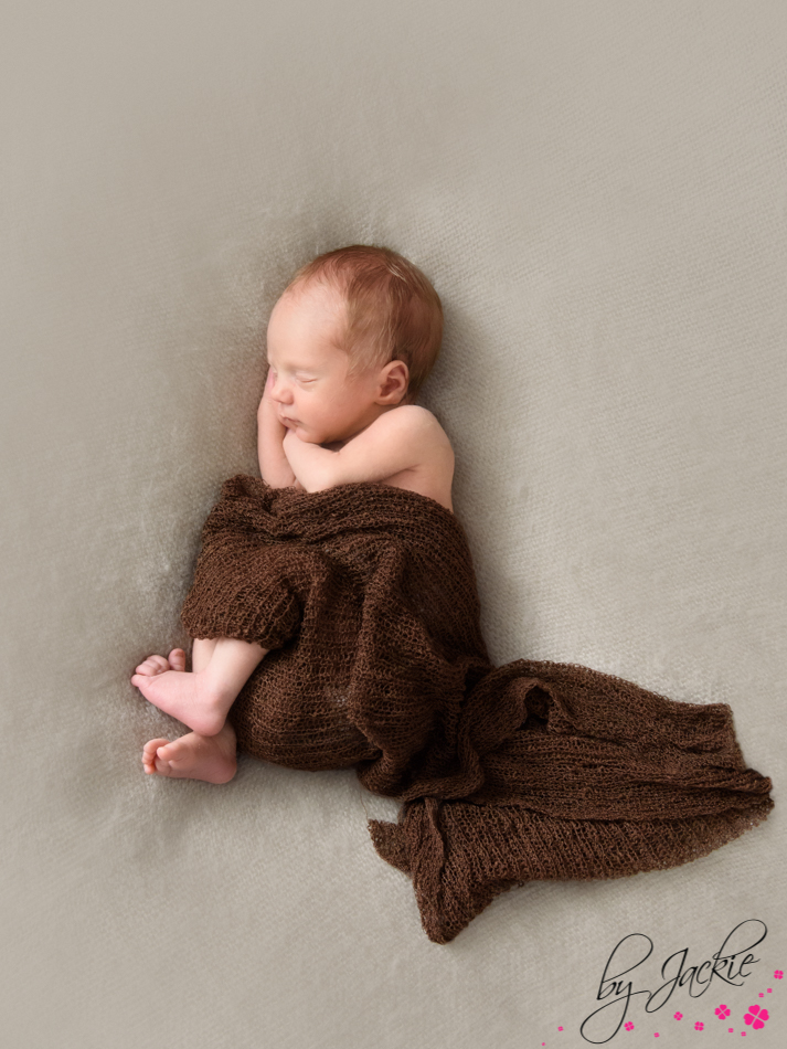 Photograph of newborn baby boy wrapped and asleep, by Babies By Jackie in Yorkshire UK