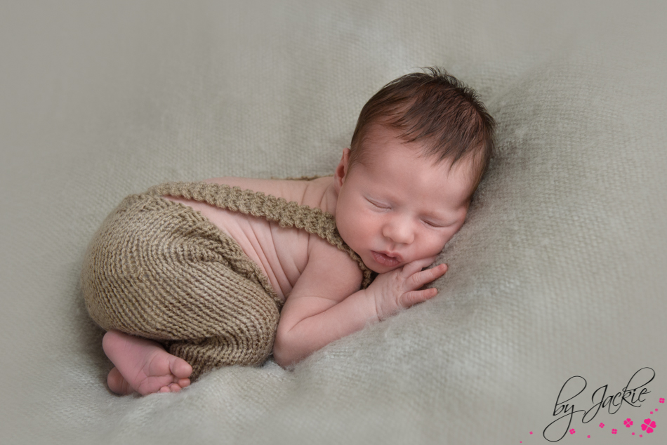 Image of a newborn baby boy snuggled in his rompers near whitby, north yorkshire Photo by Babies By Jackie in York