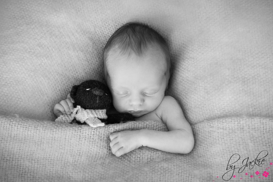 Monochrome photo of newborn baby boy fast asleep with his teddy bear. Babies By Jackie near Acomb, York