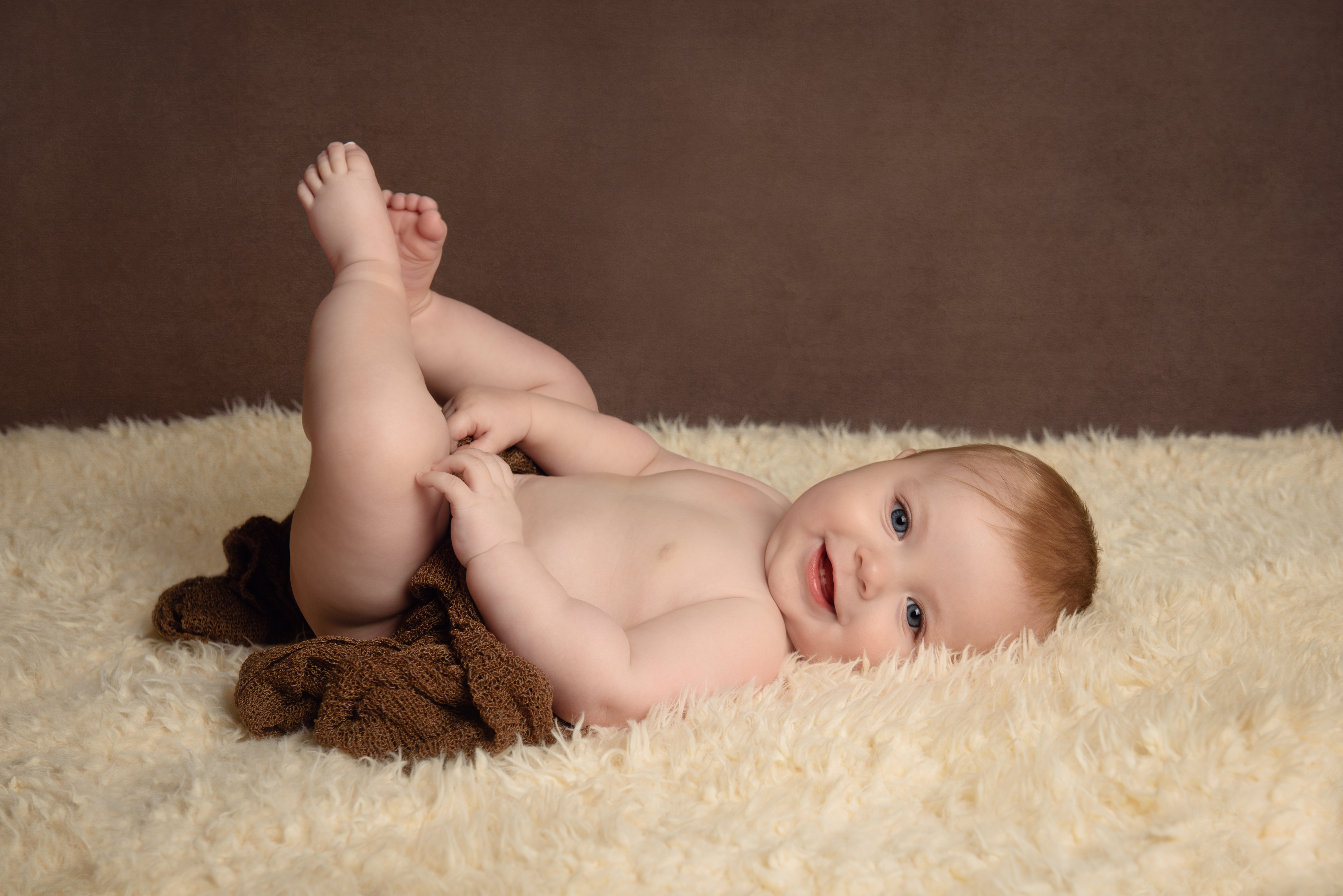 6 month baby boy playing with toes. Photo by Babies By Jackie near Pocklington, Beverley and Hull