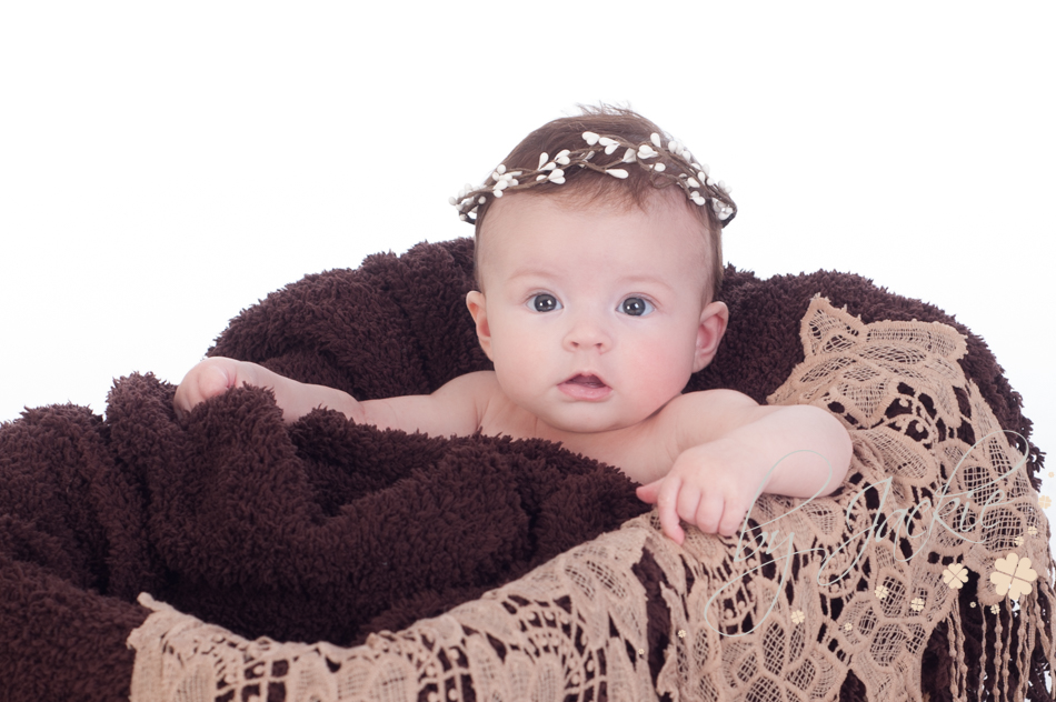 4 month old baby girl sitting in crate for her milestone photoshoot with Babies By Jackie near Howden