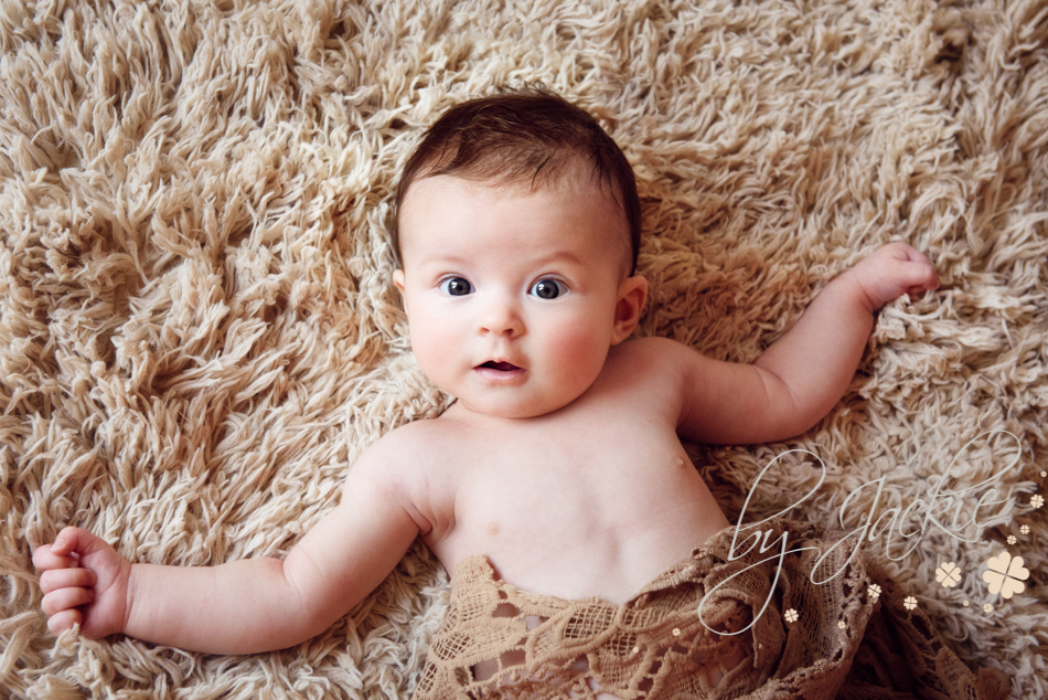 Cute little baby girl looking at the camera. Milestone photo session image by Babies By Jackie near York