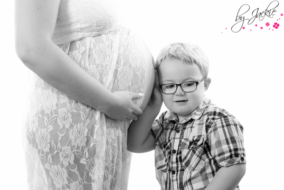 Photo of little boy with head to mum's bump, listening for his unborn baby brother. Babies By Jackie, Yorkshire UK