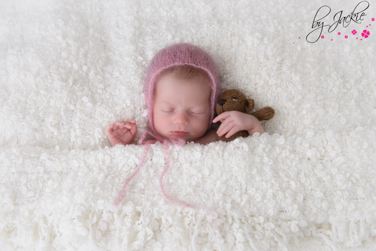 Photo of newborn baby girl in pink mohair bonnet asleep with her teddy bear BY Jackie Photography York, North Yorkshire